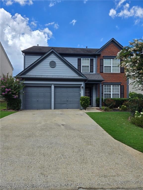 Traditional-style house featuring concrete driveway, a front lawn, and an attached garage
