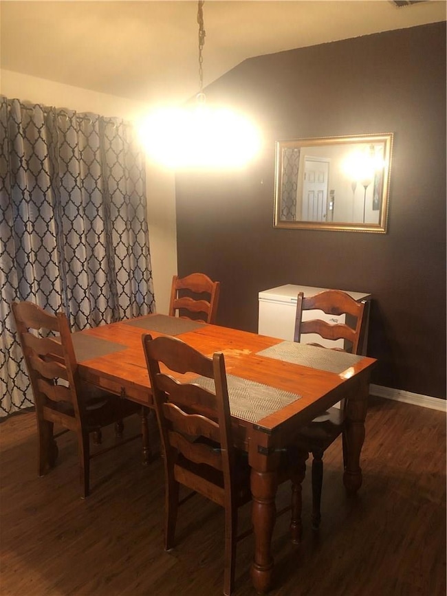 Dining room with wood finished floors and lofted 