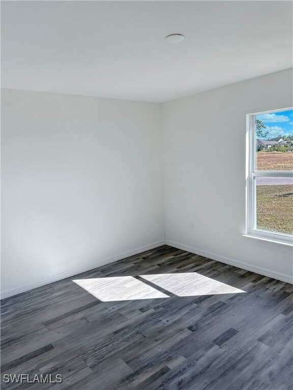 Unfurnished room with dark wood-type flooring and