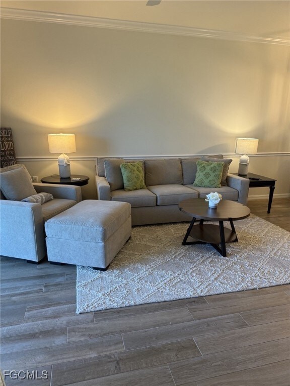 Living area with crown molding and wood finished floors
