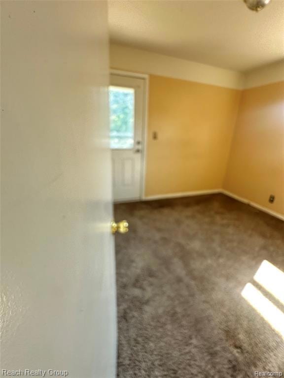 Empty room featuring carpet and baseboards