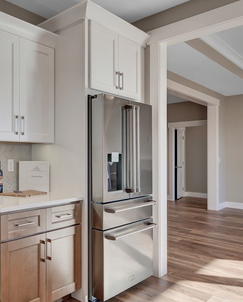 (PHOTO OF SIMILAR HOME)Kitchen with high end refrigerator, light wood-style flooring, white cabinets, and tasteful backsplash