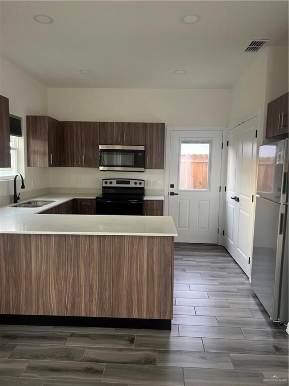 Kitchen with range, fridge, healthy amount of natural light, light countertops, and recessed lighting