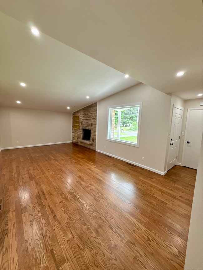 Vaulted ceiling, fireplace, hardwood, more recessed lighting.