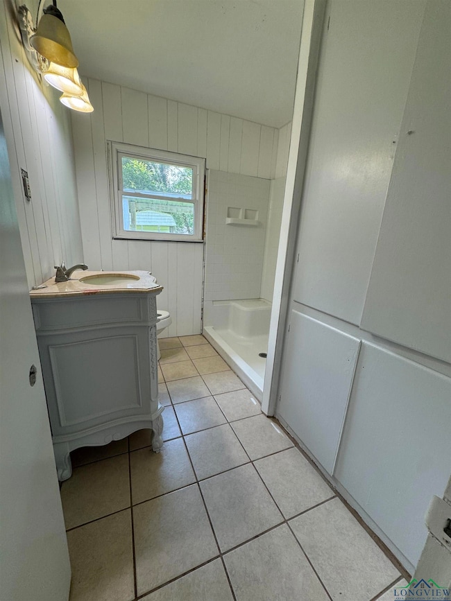 Bathroom featuring a shower stall, tile patterned floors, and vanity