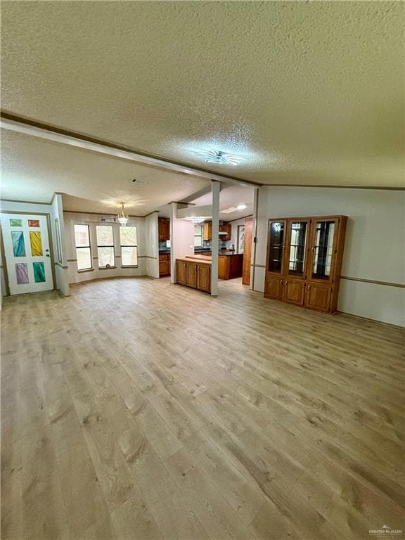 Unfurnished living room featuring a textured ceiling and light wood-style flooring