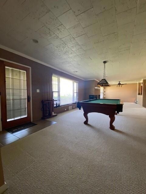 Unfurnished living room with carpet flooring, a brick fireplace, crown molding, and billiards