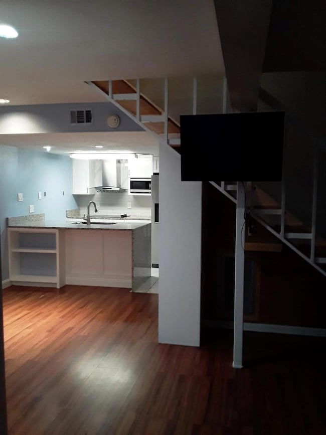 Basement with sink, stainless steel fridge, and wo