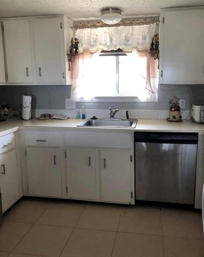 Kitchen with white cabinets, sink, dishwasher, and