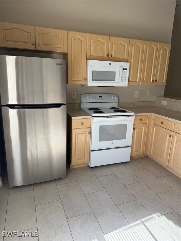 Kitchen featuring fridge, electric stove, light br