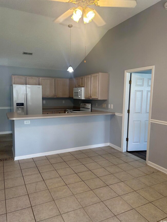 Kitchen featuring ceiling fan, hanging light fixtu