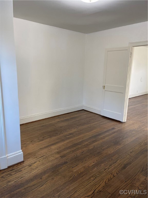 Spare room with dark wood-type flooring