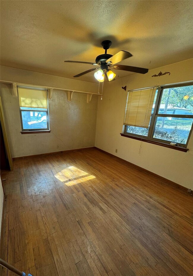 Bedroom 1 with original hardwood wood floors, a he
