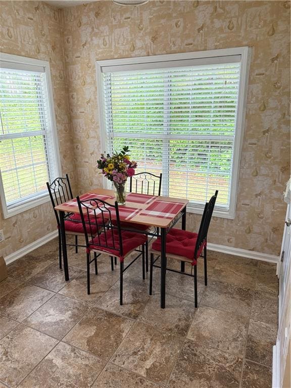 Dining room with baseboards and wallpapered walls