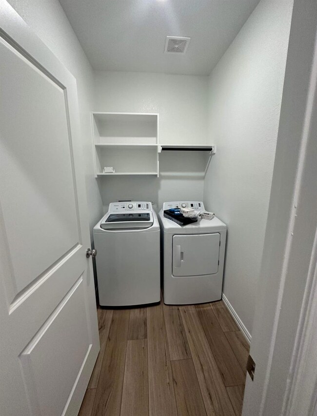 Laundry area with laundry area, wood finished floo