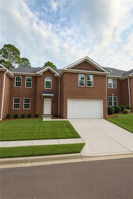 View of front of home with concrete driveway, a front yard, brick siding, and a garage
