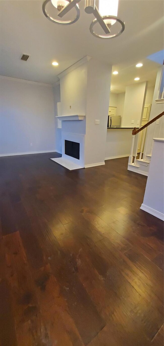 Unfurnished living room featuring dark wood-type f