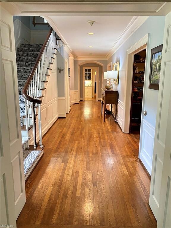 The grand hallway with wood floors and crown moldi