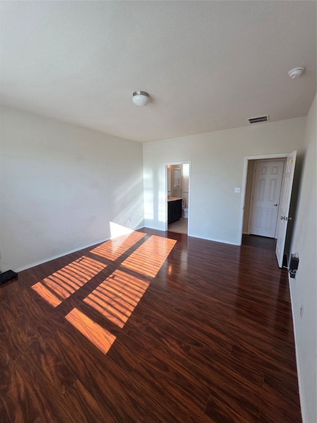 Unfurnished room featuring dark wood-style floors and a smoke detector