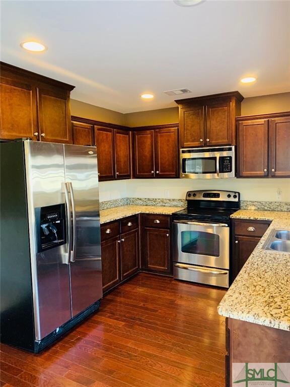 Kitchen with wood floors, granite counters and sta