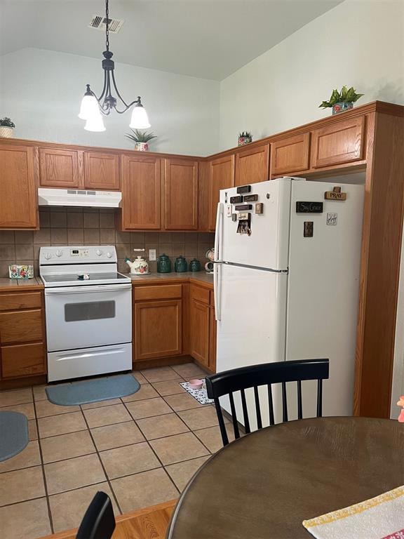 Kitchen with stove, refrigerator, ventilation hood, decorative backsplash, and brown cabinetry