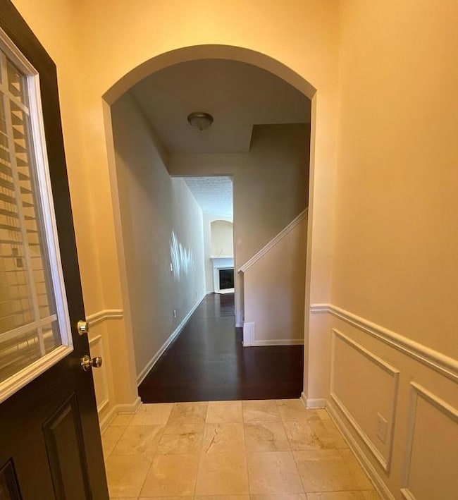 Hall with arched walkways and light marble finish flooring