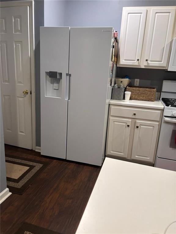Kitchen with white cabinets, fridge with ice dispenser, white range with gas stovetop, dark wood finished floors, and light countertops