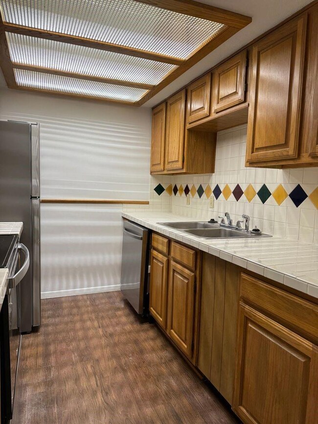 Kitchen featuring dishwasher, tile countertops, da