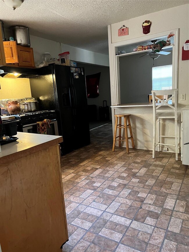 Kitchen featuring range, a textured ceiling, a kit