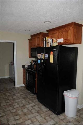 Another view of the  kitchen with the stove and fridge.