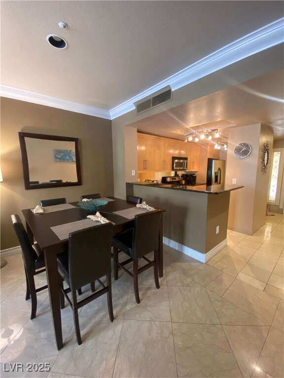 Dining area with baseboards, visible vents, marble