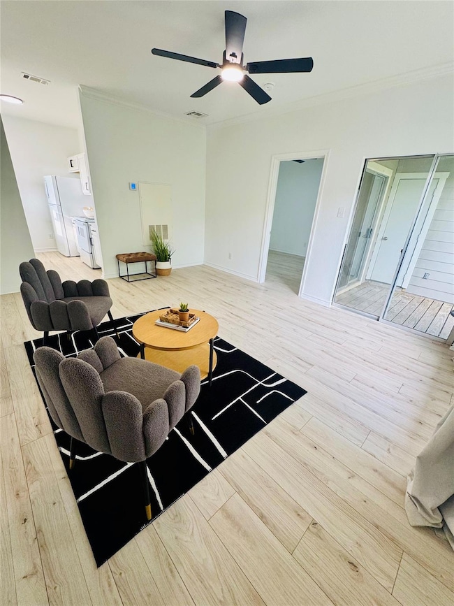 Living room with visible vents, a ceiling fan, an
