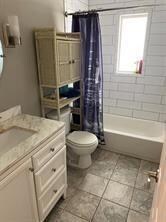 Full bathroom featuring vanity, toilet, tile patterned floors, and shower / tub combo