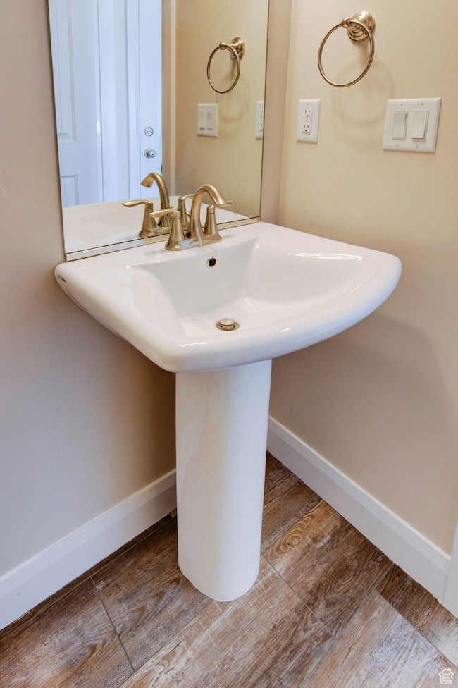 Bathroom with wood finished floors and baseboards