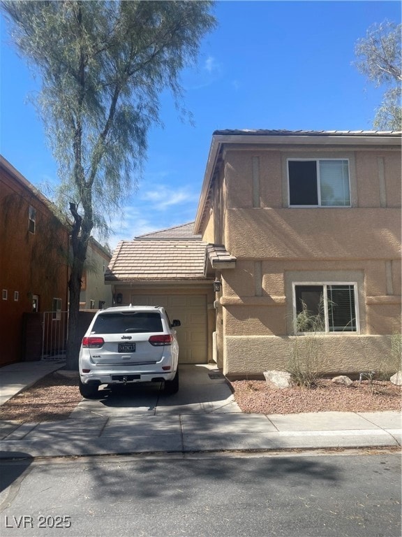 View of front of house with a garage, driveway, st