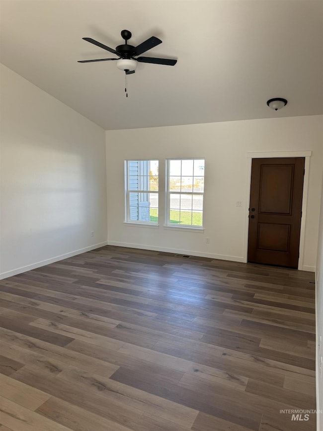 Spare room featuring dark wood-style floors and a ceiling fan