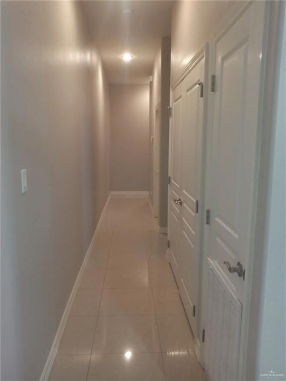 Hall with light tile patterned floors and baseboards