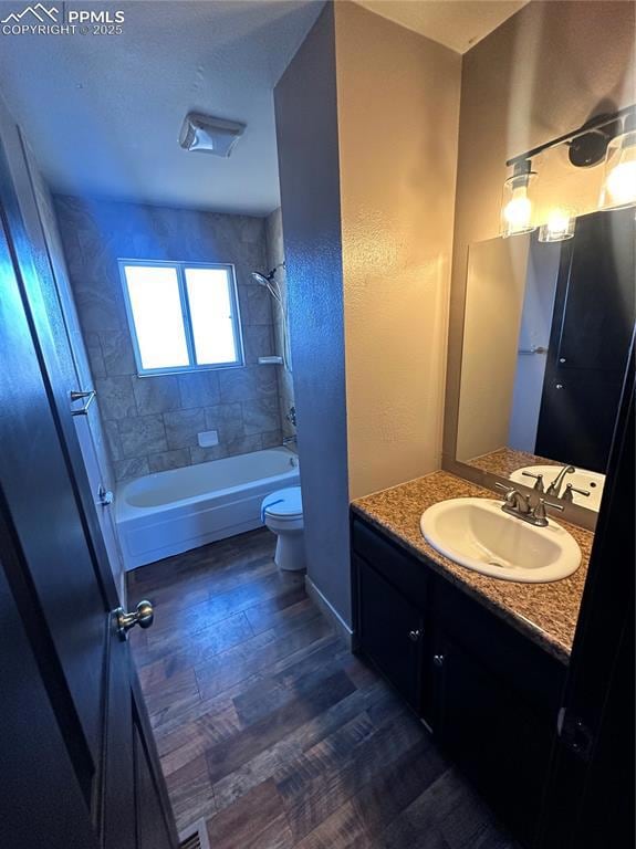 Full bath featuring vanity, dark wood-type flooring, bathtub / shower combination, a textured wall, and a textured ceiling