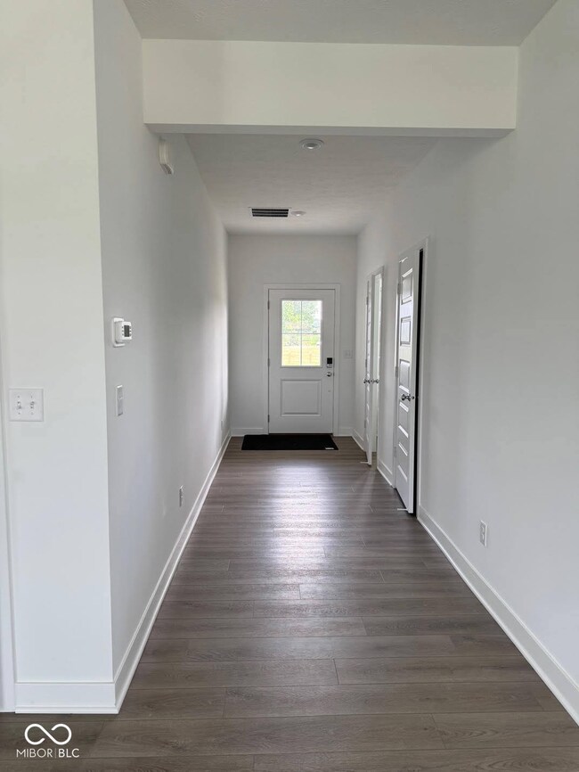 foyer entrance featuring baseboards and dark wood-style flooring