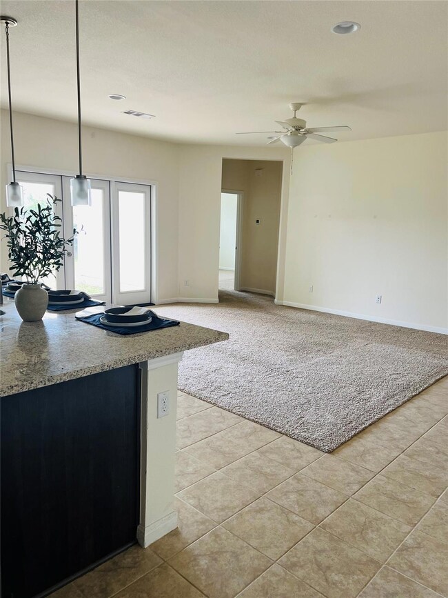 Kitchen with a ceiling fan, light tile patterned 