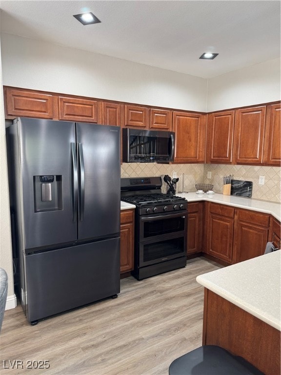 Kitchen with fridge, stove, light countertops, tas