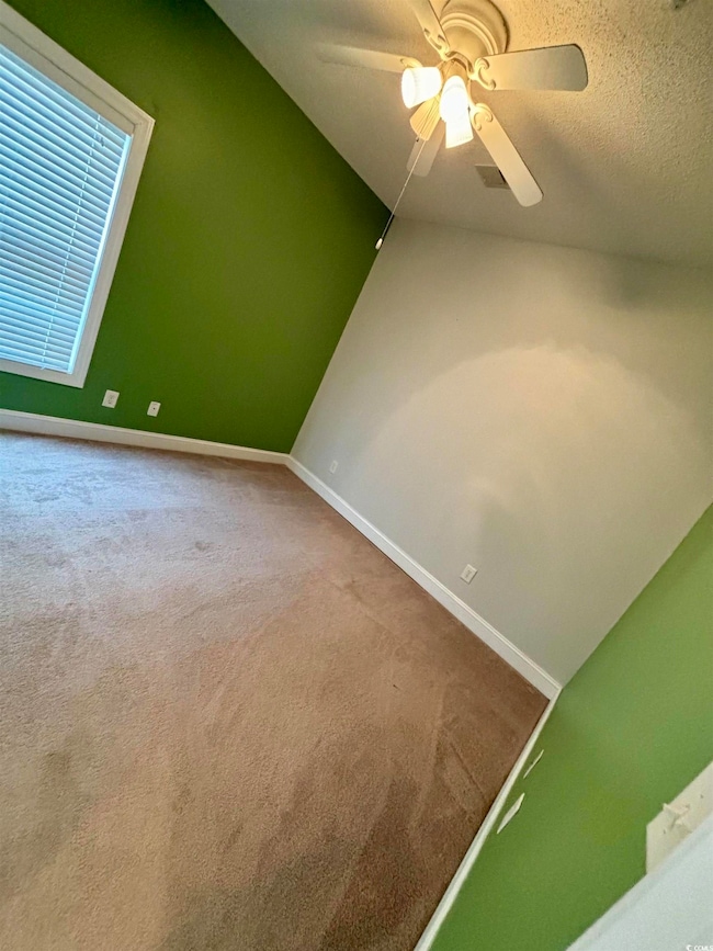 Interior space with baseboards, a textured ceiling, and ceiling fan