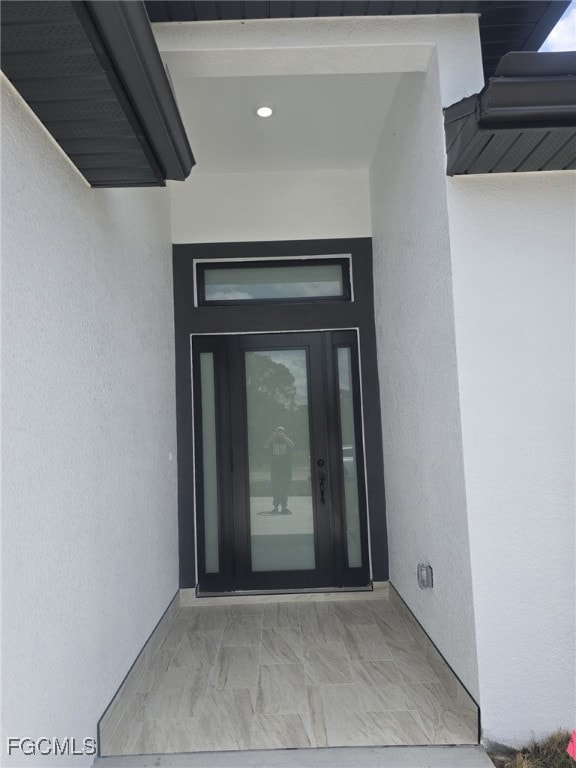 View of exterior entry featuring stucco siding