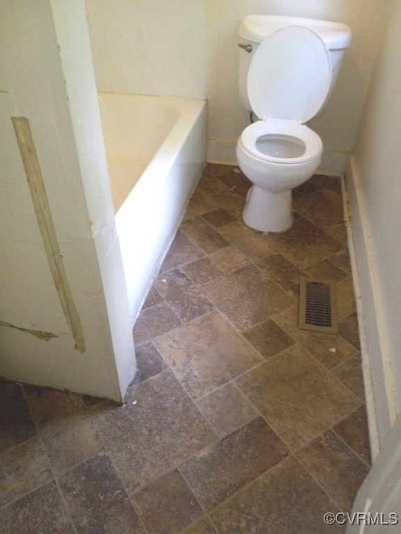 Full bath with visible vents, toilet, stone tile f