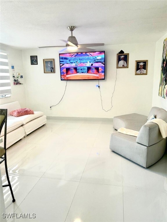 Living room with a ceiling fan and baseboards