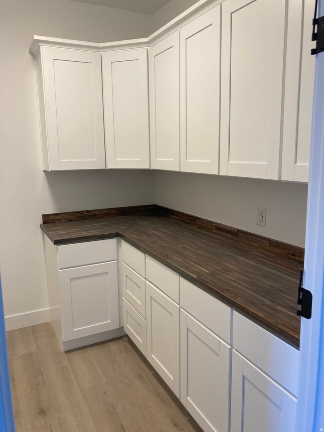 Laundry room with tons if cabinets and a work area.
