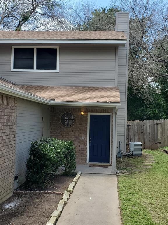 Entrance to property featuring a shingled roof, a