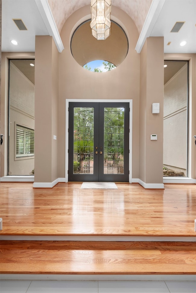 Main entry flanked side by side with floor to ceiling clerestory windows. The vaulted ceiling and circular accent window leads into  polished hardwood floor lobby.