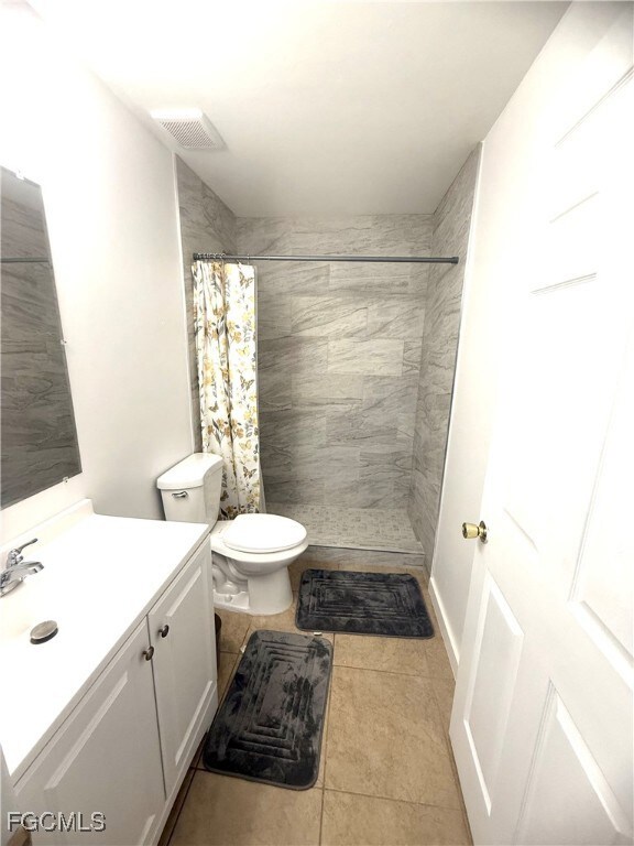Bathroom featuring vanity, a shower stall, and light tile patterned floors