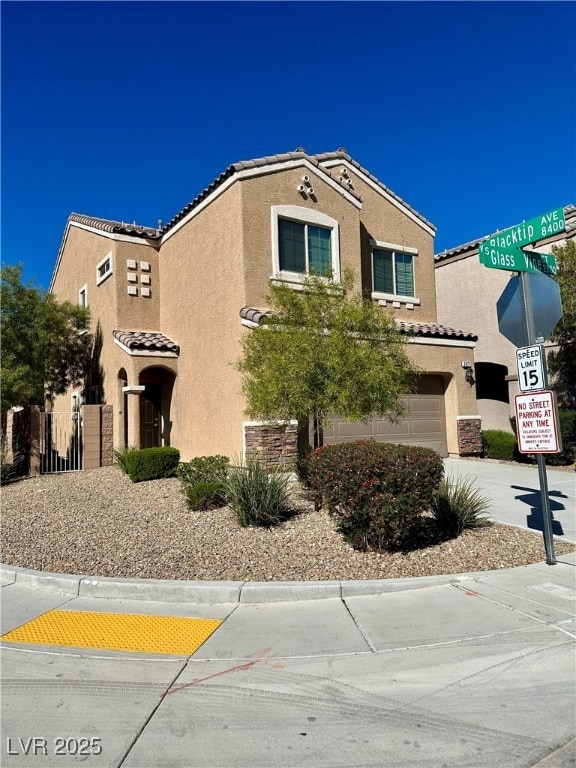 Mediterranean / spanish house featuring driveway, stucco siding, a tile roof, and a garage